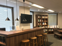 ラウンジの写真です。弊所の蔵書が全て陳列してあるので、調べものや自主学習にも、ランチやお客様との簡易的な来客にも自由に使ってOKなスペースです。（時折ここで所内の飲み会が開催されることもあります）